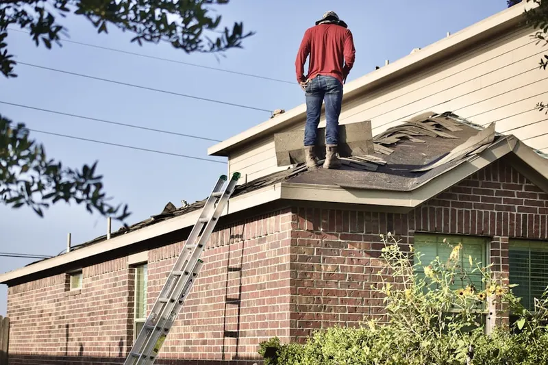 Professional roofer working on a residential roof in Tansboro
